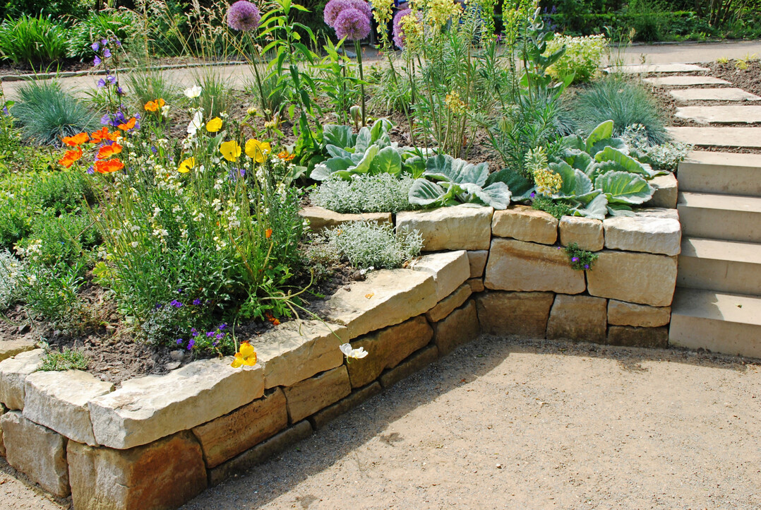 Trockenmauer und Treppe aus grau-buntem Wesersandstein mit unterschiedlich bearbeiteten Oberfl�chen