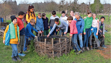Der Jugendgruppe wird die Hochbeet-Bepflanzung erklrt