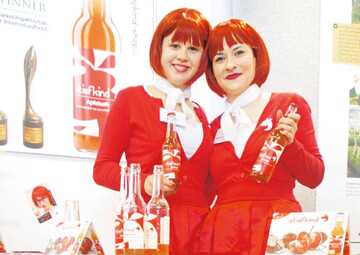 Die beiden rot gekleideten Damen prsentierten auf der Messe Fruchtwelt die Stiefkind-Produkte