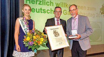 Jrgen Mertz, Prsident des Zentralverband Gartenbau e.V., und die Deutsche Blumenfee 2014/2015, Christina Aumann, gratulieren Dr. Walter Hartmann (r.) zu seiner Auszeichnung.