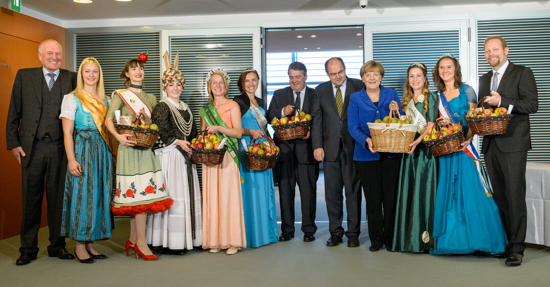 Manfred Nüssel (DRV-Präsident), Sigmar Gabriel (Bundesminister für Wirtschaft und Energie), Christian Schmidt (Bundesminister für Ernährung und Landwirtschaft), Dr. Angela Merkel (Bundeskanzlerin) und Dr. Christian Weseloh (Geschäftsführer BVEO) neben den Apfel- und Blütenköniginnen von (v.l.n.r.) Bodensee, Brandenburg, Altes Land, Sachsen, Meckenheim, Mecklenburg-Vorpommern und Schleswig-Holstein